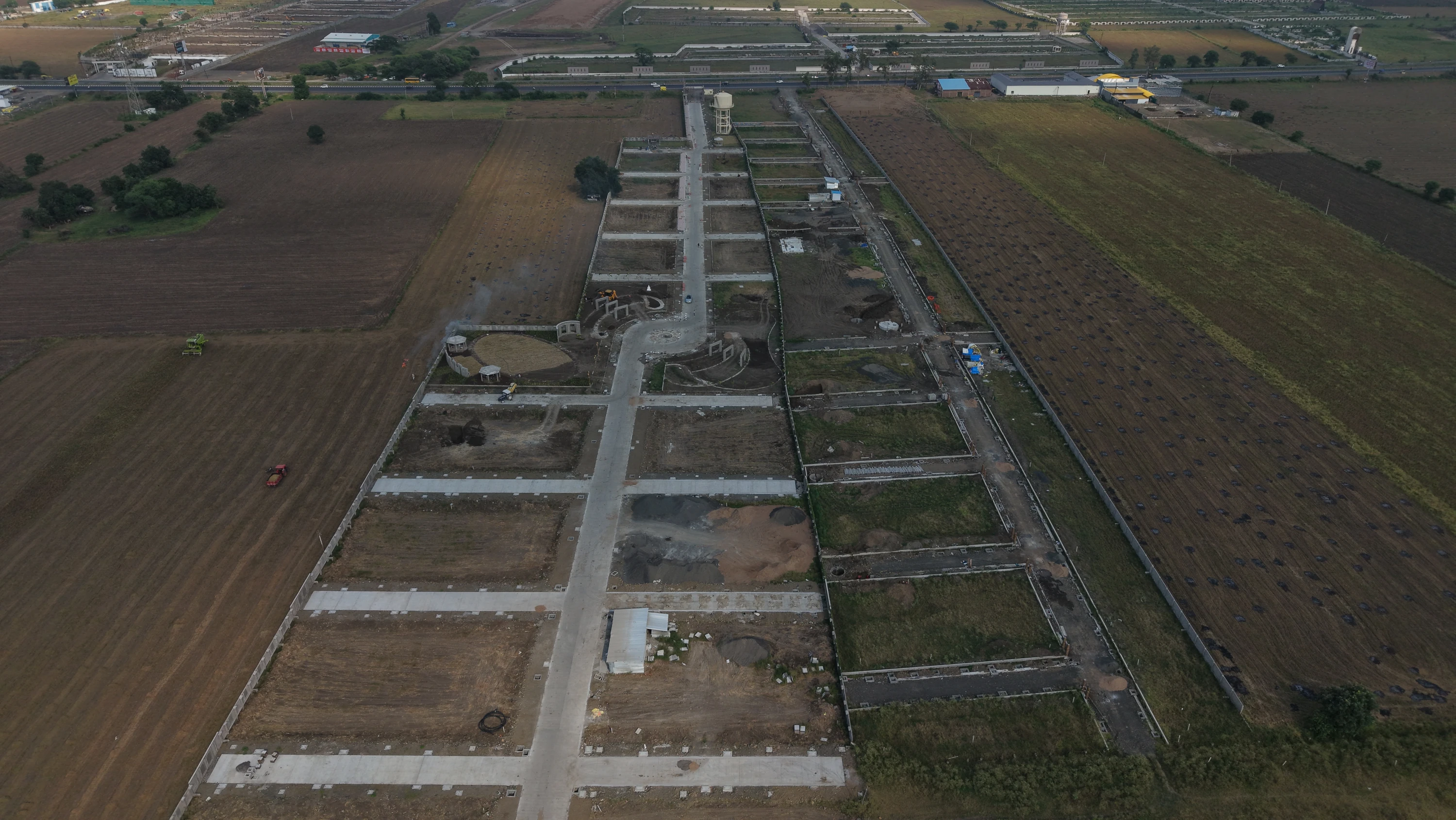 Real drone photograph of Kanak Mahakal Lok, showing its long road layout, open plots, central park and water tank